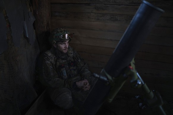 12.04.2024, Ukraine, Gebiet Donezk: Ein ukrainischer Soldat der Asow-Brigade, bekannt unter dem Rufzeichen Buk, 24, wartet auf den Befehl zum Feuern auf Stellungen von 122 mm HM 16 Mörsern etwa einen  ...