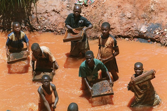 Mineurs de diamants en Republique Democratique du Gongo Diamond miners in the Democratic Republic of Gonco Des enfants mineurs de diamants tamisent le minerai dans un cours d eau pres d une mine artis ...