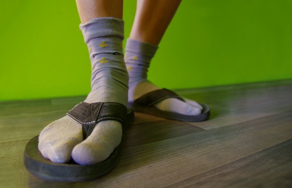 Close up of feet with socks in flip flops