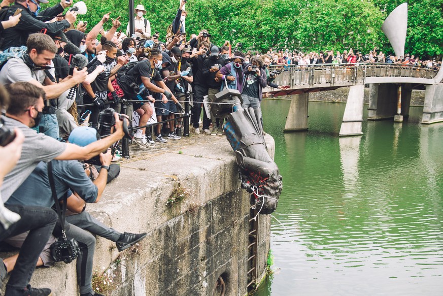 Menschen stürzen die Statue von Edward Colston ins Wasser. Edward Colston war ein Sklavenhändler im späten 17. Jahrhundert.