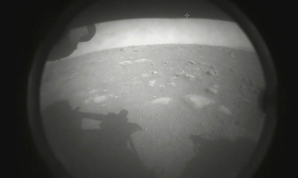 HANDOUT - 18.02.2021, ---: Dieses von der NASA zur Verf�gung gestellte Foto zeigt das erste vom Perseverance-Rover gesendete Bild der Marsoberfl�che, kurz nach der Landung im Jezero-Krater. (Wiederhol ...