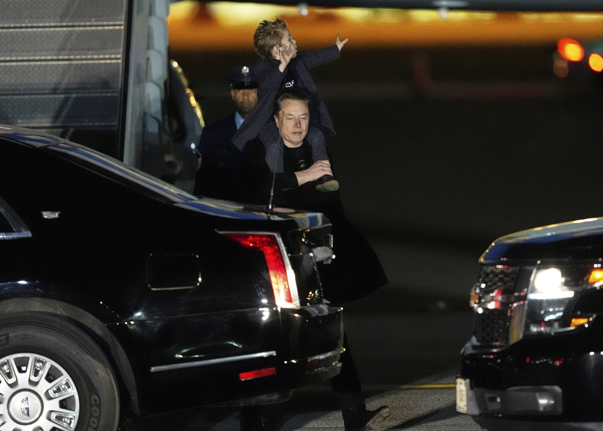 Elon Musk carries his son X Æ A-Xii as they arrives on Air Force One with President Donald Trump, not pictured, at Miami International Airport, Saturday, April 12, 2025, in Miami, Fla. (AP Photo/Manue ...
