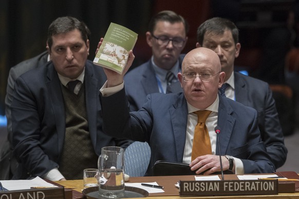 Russian Ambassador to the United Nations Vassily Nebenzia holds up a copy of &quot;Alice's Adventures in Wonderland&quot; as he speaks during a Security Council meeting on the situation between Britai ...