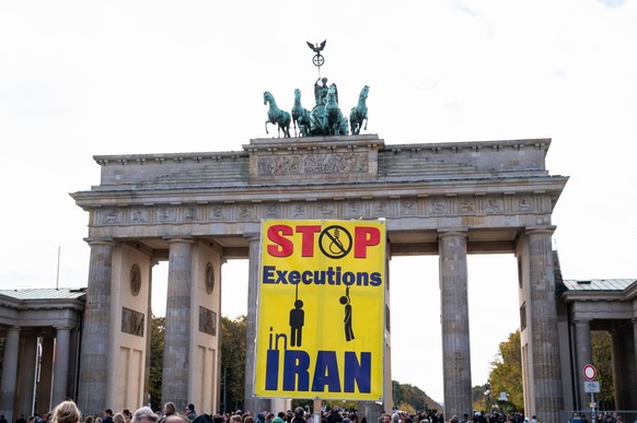 15.10.2022, Berlin, Deutschland, Europa - Protestplakat waehrend einer Kundgebung vor dem Brandenburger Tor mit dem Schriftzug Stop Executions in Iran richtet sich gegen Hinrichtungen im Iran. *** 15  ...