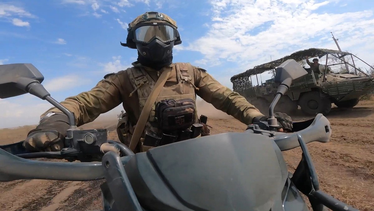 HANDOUT - 12.08.2024, Ukraine, ---: Auf diesem vom Pressedienst des russischen Verteidigungsministeriums via AP veröffentlichten Video-Standbild fährt ein Mitglied eines Marine-Teams auf einem Motorra ...