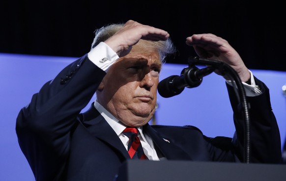 U.S. President Donald Trump shield his eyes from stage lights as he take questions from members of the media during a news conference before departing the NATO Summit in Brussels, Belgium, Thursday, J ...