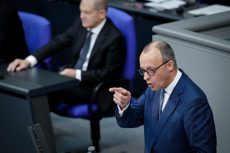 14.12.2022, Berlin: Friedrich Merz (CDU), CDU-Bundesvorsitzender und Unionsfraktionsvorsitzender, spricht neben Bundeskanzler Olaf Scholz (l, SPD) im Bundestag nach der Regierungserklärung zum EU-Rat  ...