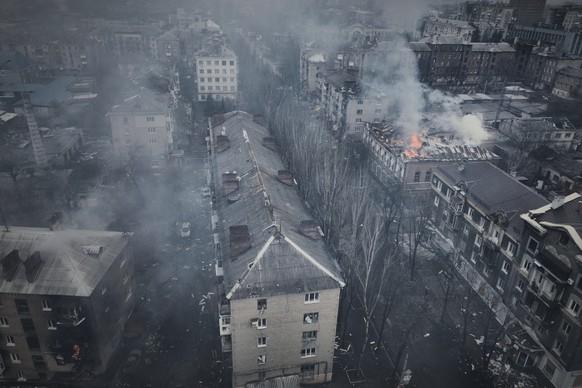 26.03.2023, Ukraine, Bachmut: Rauch steigt aus brennenden Gebäuden in einer Luftaufnahme von Bachmut auf, dem Ort schwerer Kämpfe mit russischen Truppen in der Region Donezk. Foto: Libkos/AP/dpa +++ d ...