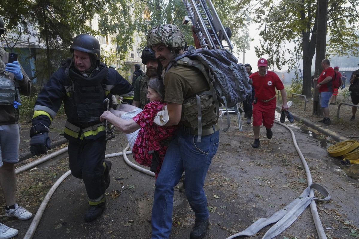 30.08.2024, Ukraine, Charkiw: Retter tragen einen Bewohner, der durch einen russischen Bombenangriff verletzt wurde. Bei einem russischen Angriff auf die nordöstliche Stadt mit Gleitbomben aus Flugzeu ...