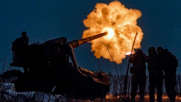 ARCHIV - 15.12.2022, Ukraine, Bachmut: Ukrainische Soldaten feuern eine Pion (M-1975) Kanonenhaubitze auf russische Stellungen in der N