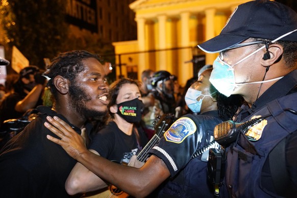 Metropolitan Police are confronted by protestors as police carry away a handcuffed protestor along a section of 16th Street, Northwest, renamed Black Lives Matter Plaza, Thursday night , Aug. 27, 2020 ...