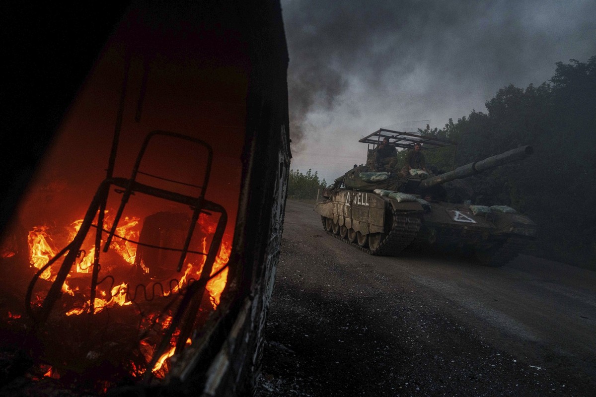 FILE - A Ukrainian tank passes by a burning car near the Russian-Ukrainian border in the Sumy region of Ukraine, Aug. 14, 2024. (AP Photo/Evgeniy Maloletka, File)