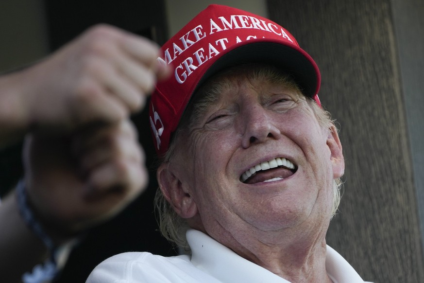 Former President Donald Trump laughs while looking over the 18th hole during the final round of the Bedminster Invitational LIV Golf tournament in Bedminster, N.J., Sunday, Aug. 13, 2023. (AP Photo/Se ...