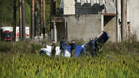 24.08.2023, Russland, Kushenkino: Russische Soldaten inspizieren ein Teil eines abgestürzten Privatjets. Der russische Söldnerführer Jewgeni Prigoschin ist nach Angaben seines Telegram-Kanals Grey Zon ...