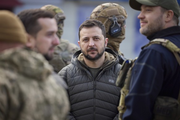 14.11.2022, Ukraine, Cherson: Wolodymyr Selenskyj (M), Präsident der Ukraine, ist umgeben von Sicherheitskräften, während er einen Rundgang durch die zurückeroberte Stadt Cherson macht. Foto: Ukraine  ...