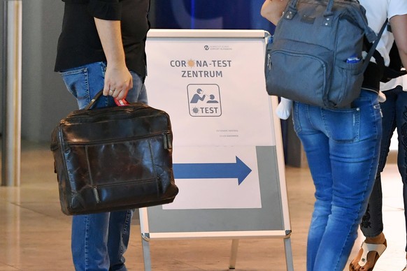 Kostenlose Corona Tests an deutschen Flughaefen,so wie hier am Albrecht Duerer Airport in Nuernberg am 01.08.2020. Reisende mit ihrem Gepaeck passieren ein Schild, das auf das Corona Test Zentrum im T ...