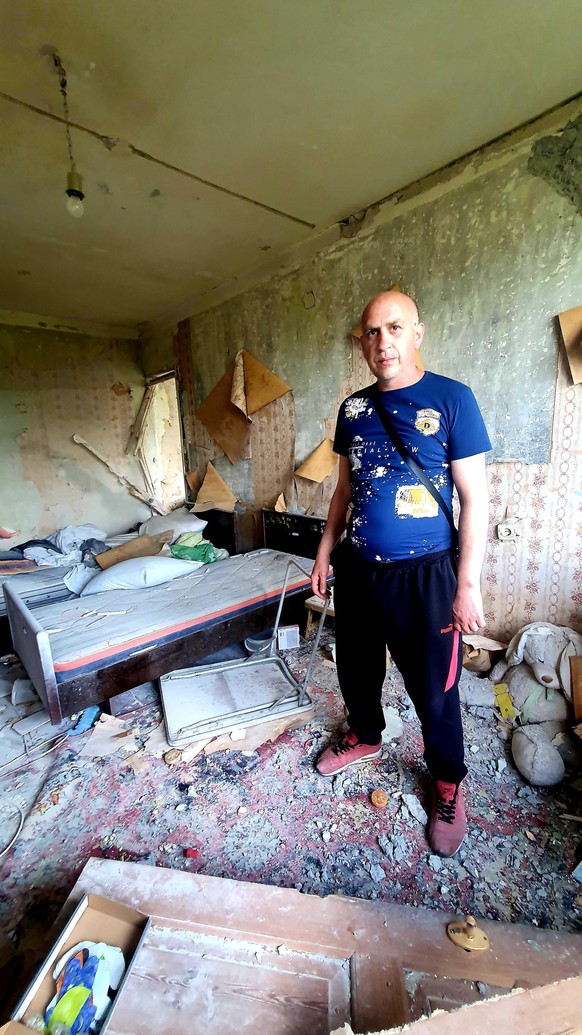 Oleksandr steht in seiner Wohnung im Norden Charkiws. In sein Schlafzimmer ist ein Artilleriegeschoss eingeschlagen.