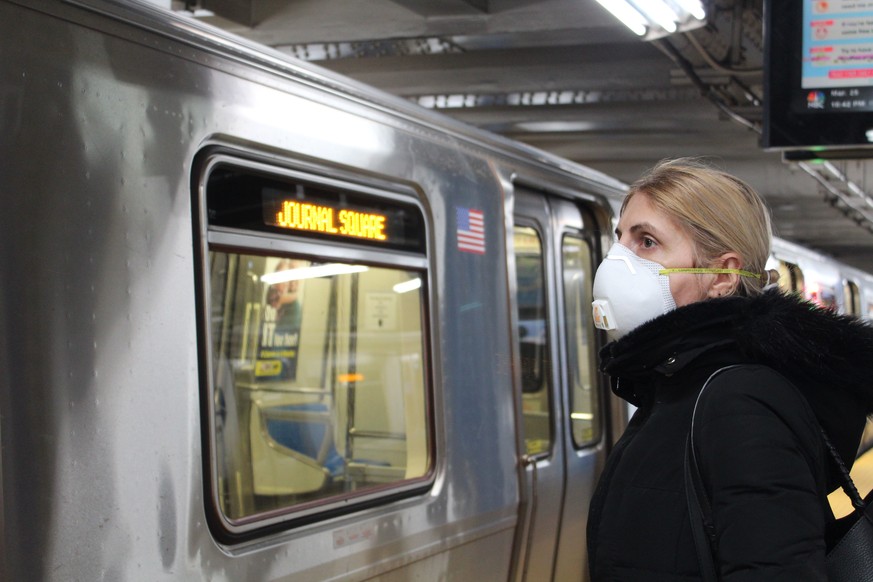 Eine junge Frau in New York trägt wegen der Corona-Krise eine Atemschutzmaske. 