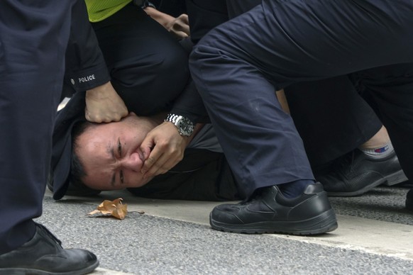 Sonntag, 27. November 2022: Polizisten halten einen Demonstranten in Shanghai fest.
