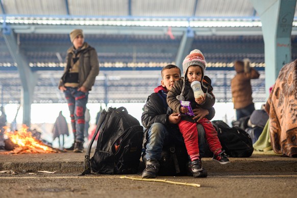 Zwei geflüchtete Kinder aus Syrien sitzen in der türkischen Grenzstadt Edirne nahe des Grenzübergangs Pazarkule-Kastanies in einer leeren Markthalle.