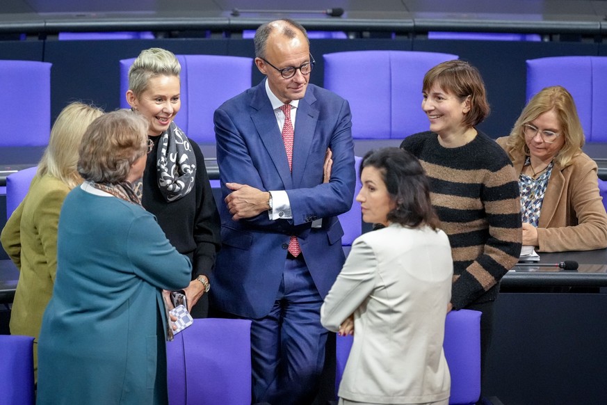 dpatopbilder - 06.12.2024, Berlin: Friedrich Merz (CDU,M), CDU-Bundesvorsitzender und Unionsfraktionsvorsitzender, steht im Plenum des Bundestags mit Abgeordneten der Unions-Fraktion zusammen. Thema i ...