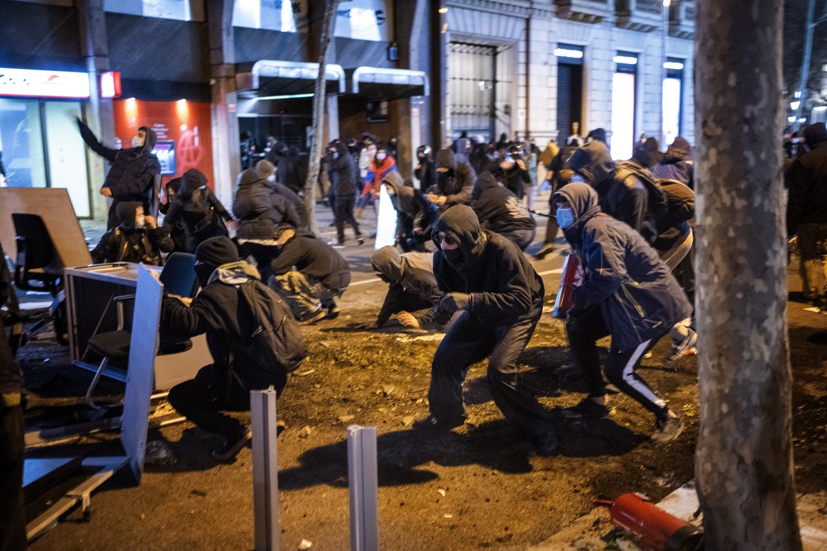 Demonstrators clash with police after a protest condemning the arrest of rap singer Pablo Hasél in Barcelona, Spain, Tuesday, Feb. 16, 2021. Violent street protests have erupted in some Spanish cities ...