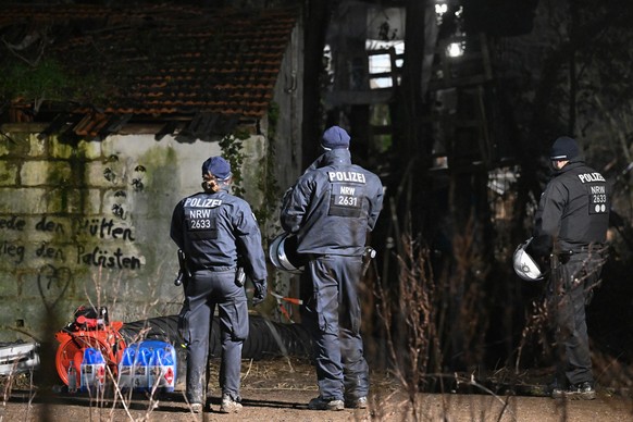 15.01.2023, Nordrhein-Westfalen, Erkelenz: Polizisten stehen in Lützerath vor dem Gebäude, in dem sich der Eingang zu dem Tunnel befinden soll, in dem sich zwei Klimaaktivisten verschanzt haben. Der E ...