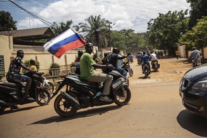 Supporters of Capt. Ibrahim Traore parade waving a Russian flag in the streets of Ouagadougou, Burkina Faso, Sunday, Oct. 2, 2022. Burkina Faso's new junta leadership is calling for calm after the Fre ...