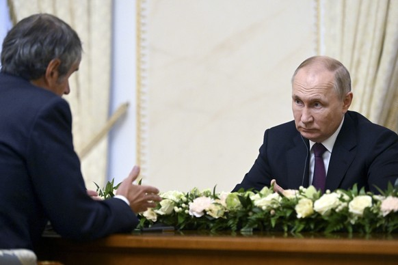 Russian President Vladimir Putin, right, listens to International Atomic Energy Agency (IAEA) Director General Rafael Mariano Grossi during their meeting in St. Petersburg, Russia, Tuesday, Oct. 11, 2 ...