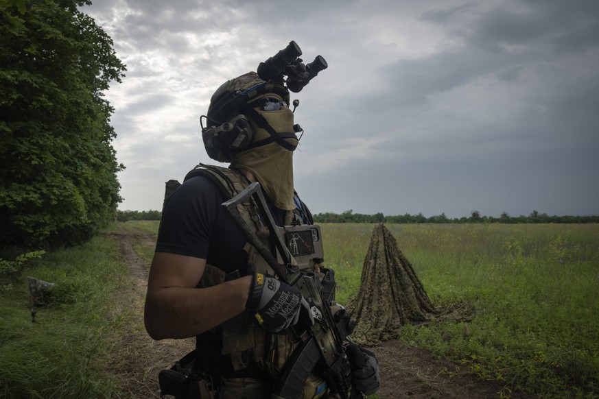 A Ukrainian soldier looks at the sky searching for a drone on the frontline in Zaporizhzhia region, Ukraine, Saturday, June 24, 2023. (AP Photo/Efrem Lukatsky)