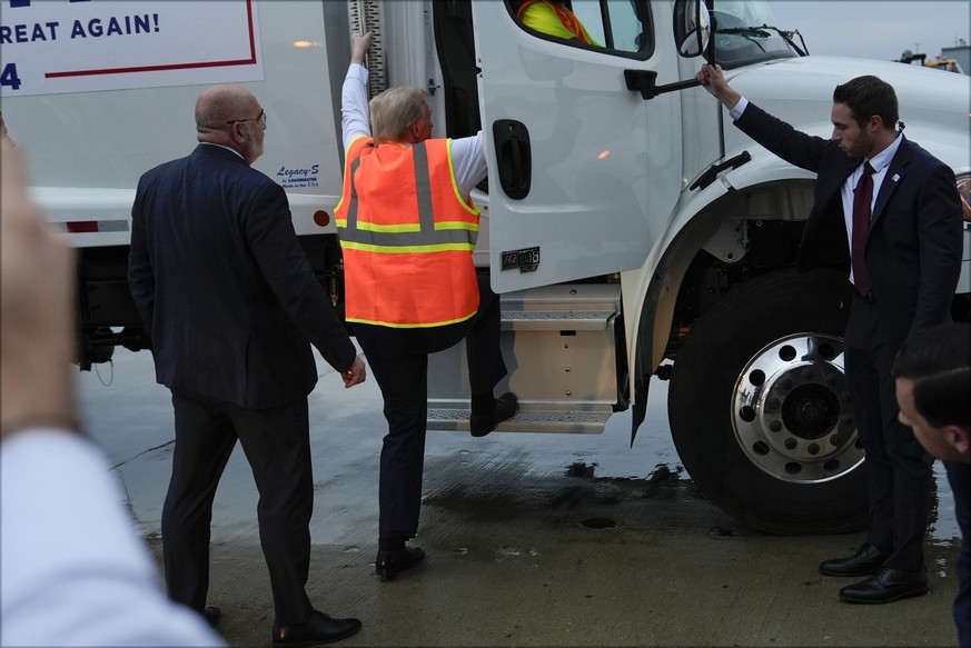 30.10.2024, USA, Green Bay: Der republikanische Präsidentschaftskandidat und ehemalige US-Präsident Donald Trump klettert in einen Müllwagen. Foto: Julia Demaree Nikhinson/AP/dpa +++ dpa-Bildfunk +++