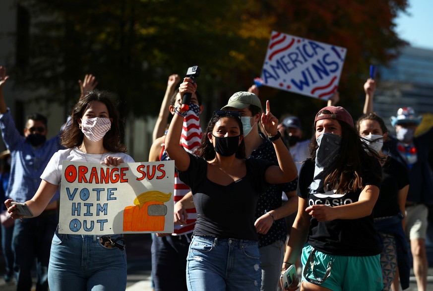 People react as media announce that Democratic U.S. presidential nominee Joe Biden has won the 2020 U.S. presidential election, on Black Lives Matter Plaza in Washington, U.S., November 7, 2020. REUTE ...