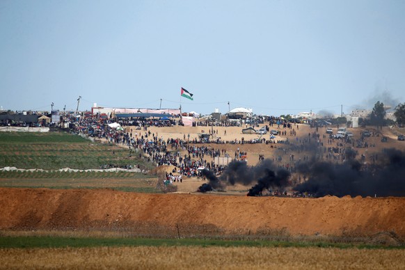 Smoke rises as Palestinians protest near the border fence on the Gaza side of the Israel-Gaza border, as seen from the Israeli side of the border, May 14, 2018. REUTERS/Baz Ratner
