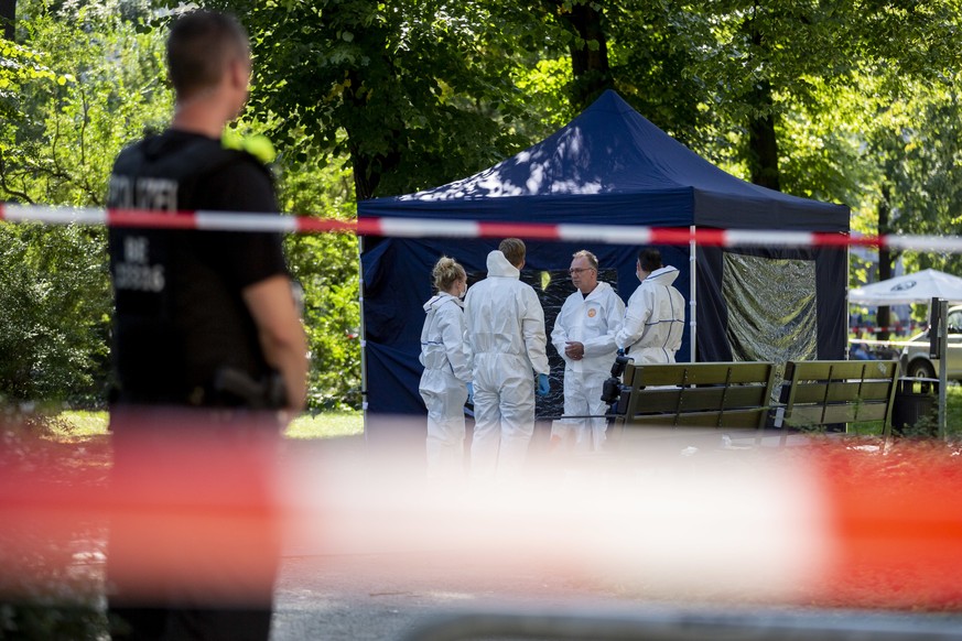 23.08.2019, Berlin: Beamte der Spurensicherung sichern in einem Faltpavillon Spuren am Tatort. In Berlin-Moabit soll ein Fahrradfahrer einen Mann erschossen haben. Foto: Christoph Soeder/dpa | Verwend ...