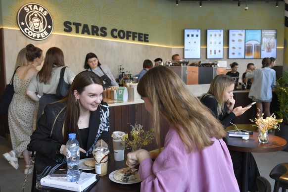 230110 -- BEIJING, Jan. 10, 2023 -- People sit inside the newly-opened Stars Coffee, a chain that opened in former Starbucks coffee shops in Moscow, Russia, Aug. 22, 2022. Photo by /Xinhua XINHUA-PICT ...