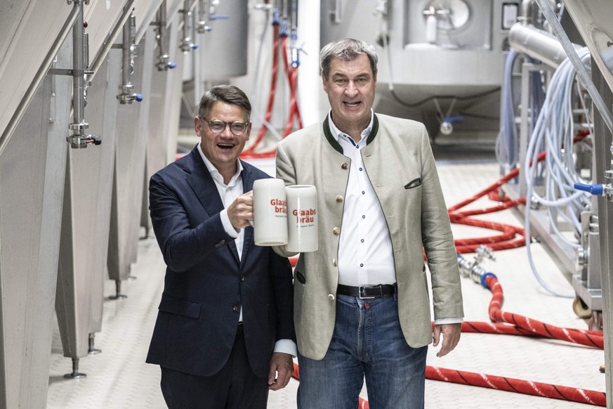 21.08.2023, Hessen, Seligenstadt: Markus Söder (CSU), Ministerpräsident von Bayern, und Boris Rhein (CDU), Ministerpräsident von Hessen, halten bei der Besichtigung der Brauerei Glaabsbräu in Seligens ...