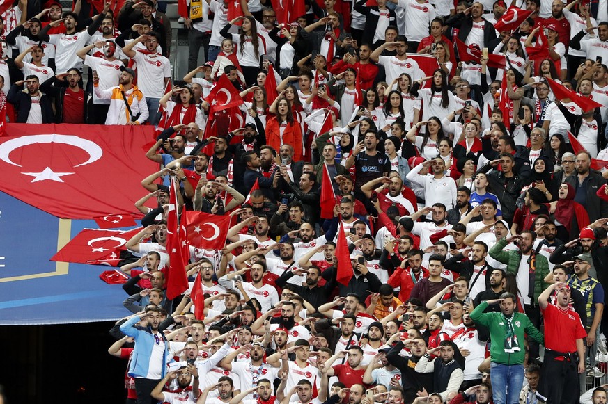 Turkish soccer team supporters shout slogans and salute before the Euro 2020 group H qualifying soccer match between France and Turkey at Stade de France at Saint Denis, north of Paris, France, Monday ...