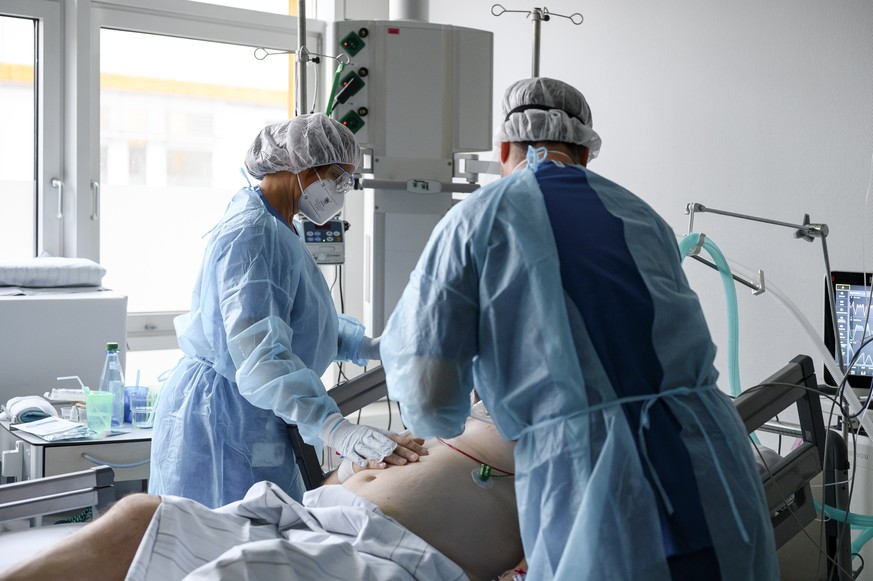 Zwei Krankenpfleger mit einem Covid-Patienten auf der Intensivstation im Klinikum Fürth.