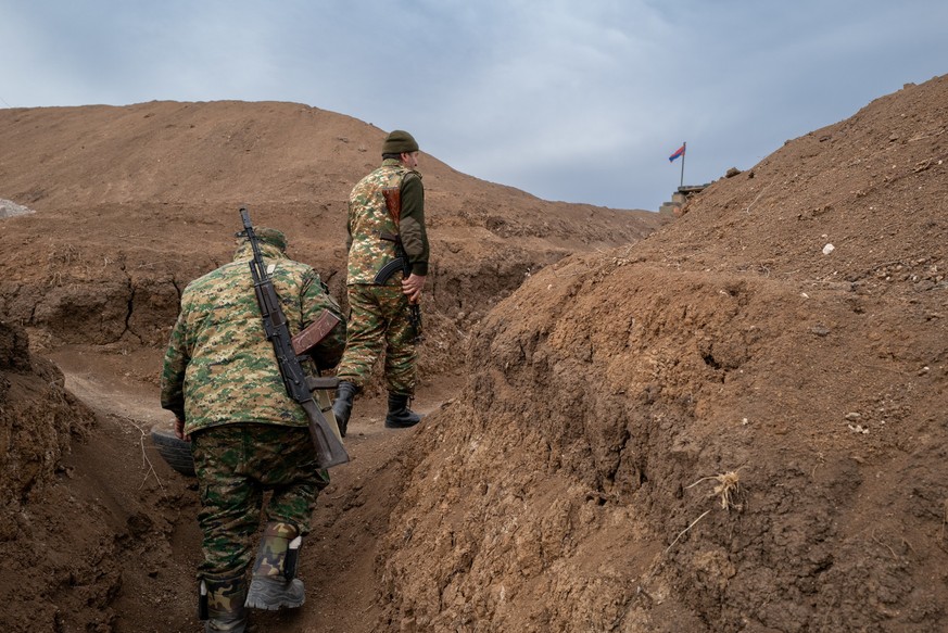 ARCHIV - 02.02.2023, Armenien, Aravus: Zwei Soldaten gehen auf einem Milit