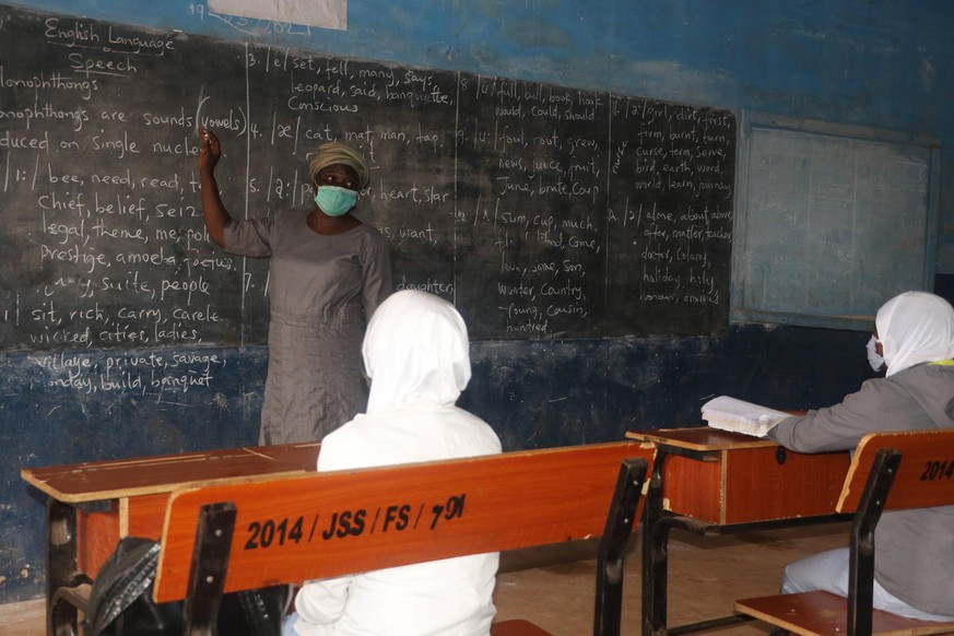 A school teacher wearing a facemask lecturing students inside the classroom at Iseyin District Grammar School. Schools in Nigeria have resumed amidst fear for safety with the new wave of coronavirus i ...