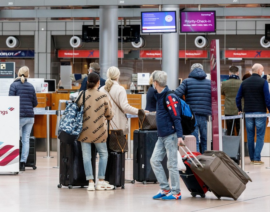 14.03.2021, Hamburg: Passagiere checken im Flughafen Hamburg zum Flug Eurowings EW 7588 nach Palma de Mallorca ein. Wegen stark sinkender Corona-Infektionszahlen hebt die Bundesregierung die Reisebesc ...