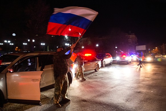 22.02.2022, Ukraine, Lugansk: Dieses von der russischen Staatsagentur Tass verbreitete Bild zeigt Menschen die auf einer Stra�e in Lugansk die Anerkennung der Unabh�ngigkeit der Volksrepubliken Donezk ...