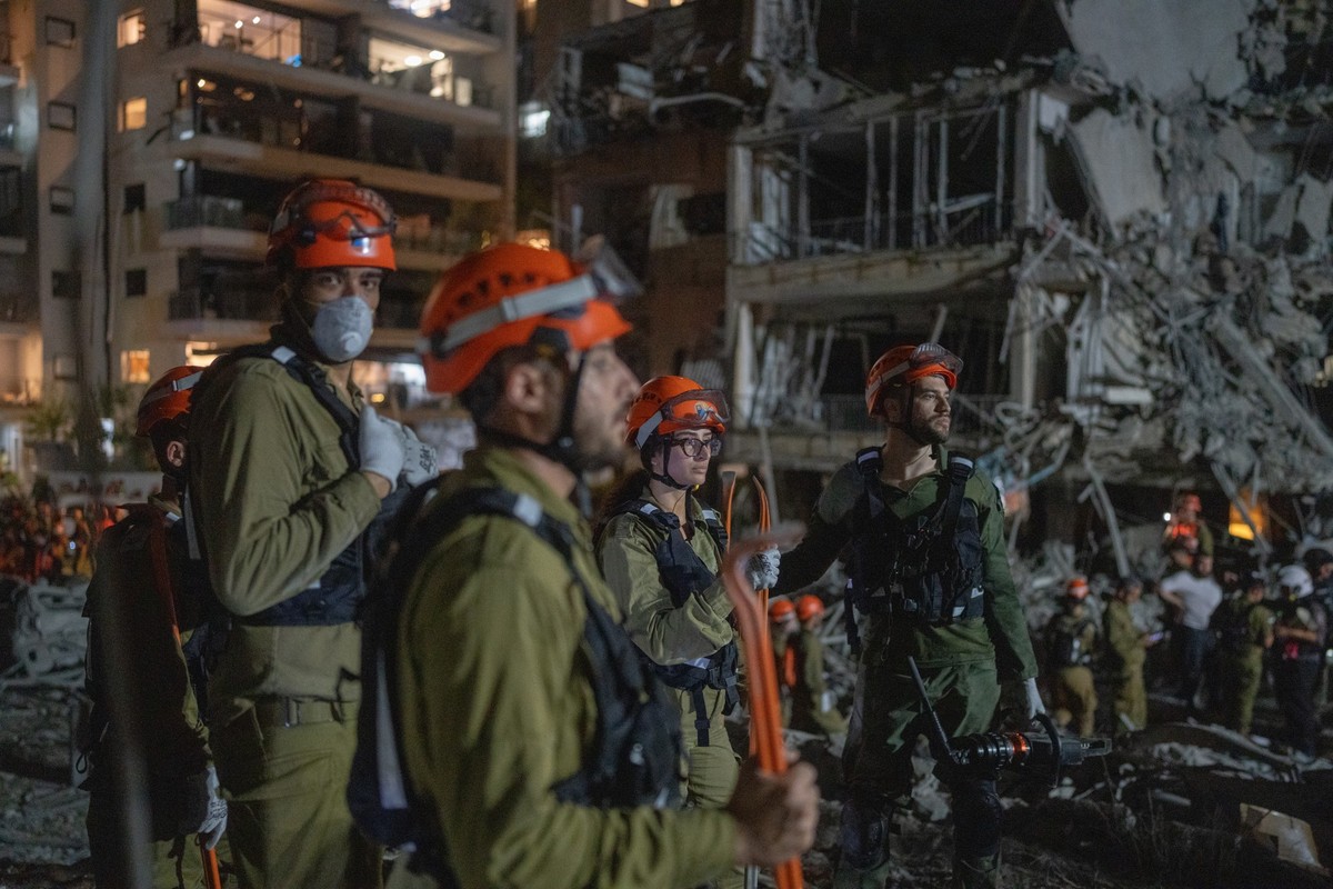 13.06.2025, Israel, Tel Aviv: Israelische Feuerwehrleute inspizieren die Schäden nach einem Raketeneinschlag in Ramat Gan in der Nähe von Tel Aviv. Foto: Ilia Yefimovich/dpa +++ dpa-Bildfunk +++