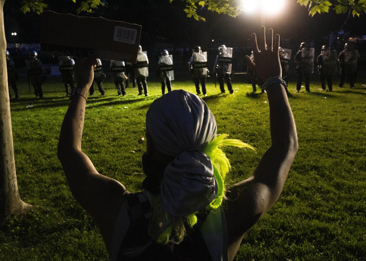 May 31, 2020, Washington, District of Columbia, USA: A protestor holds their hands in the air as police and National Guard look on during a protest in Lafayette Square in Washington, D.C., U.S., on Su ...