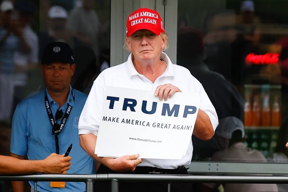 BEDMINSTER, NJ - JULY 29: Former President Donald Trump holds up a Trump Make America Great Again sign at the 16th tee box during the LIV Golf Invitational Series tee box marker during the first round ...