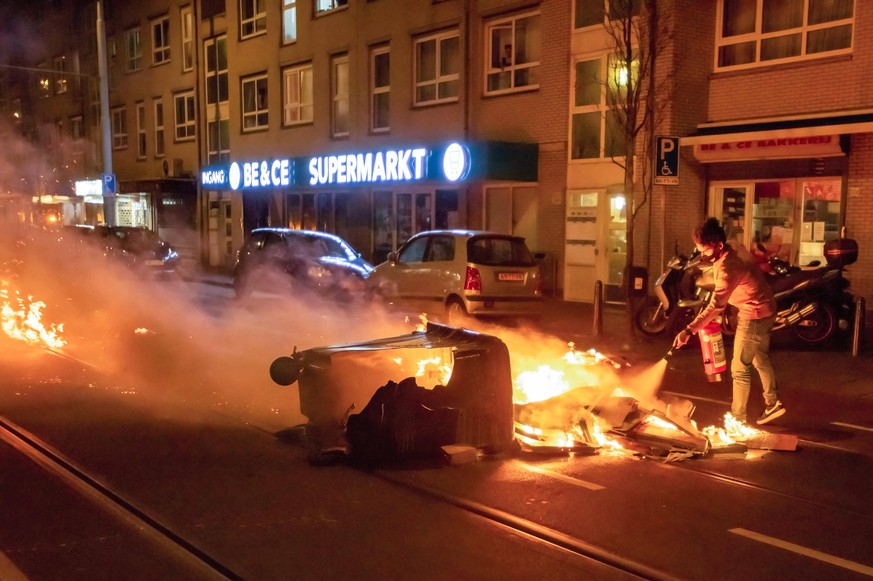 In Den Haag versuchen Anwohner, ein Feuer zu löschen. 