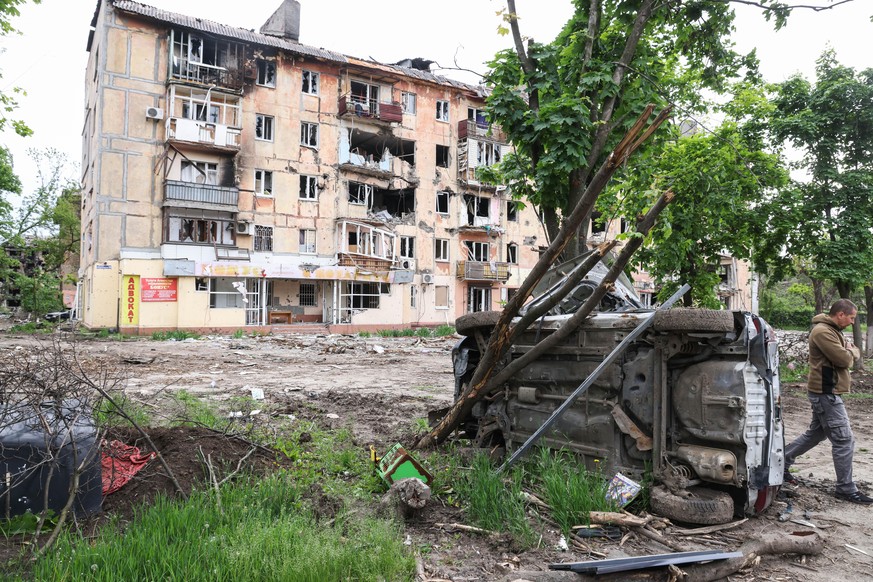 DIESES FOTO WIRD VON DER RUSSISCHEN STAATSAGENTUR TASS ZUR VERFÜGUNG GESTELLT. [DONETSK REGION, UKRAINE - MAY 22, 2022: Car wreckages near a block of flats damaged due to hostilities in Mariupol which ...