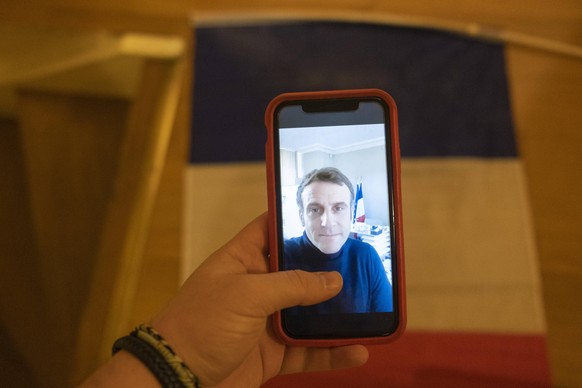 MACRON - POSITIF AU COVID-19 - TWITTER Illustration, illustration of the photo of a smartphone screen, iphone in background a French tricolor flag, video shared by the President of the French Republic ...