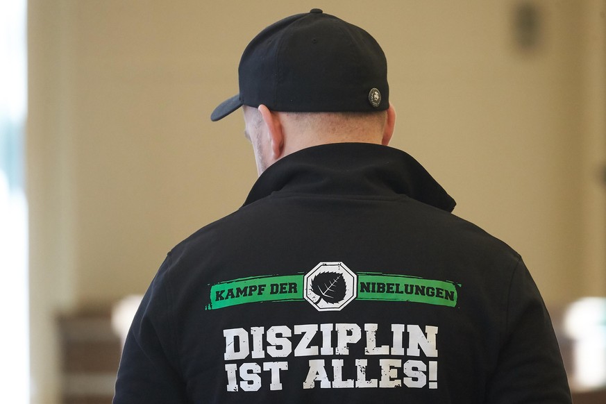 ARCHIV - 26.02.2019, Rheinland-Pfalz, Koblenz: Ein Mann trägt eine Jacke mit der Aufschrift «Kampf der Nibelungen - Disziplin ist alles!», während er im Gerichtssaal des Landgerichts auf den Beginn de ...