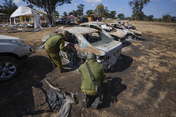 Israeli soldiers inspect the site of a music festival near the border with the Gaza Strip in southern Israel, Friday. Oct. 13, 2023. At least 260 Israeli festival-goers were killed during the attack b ...